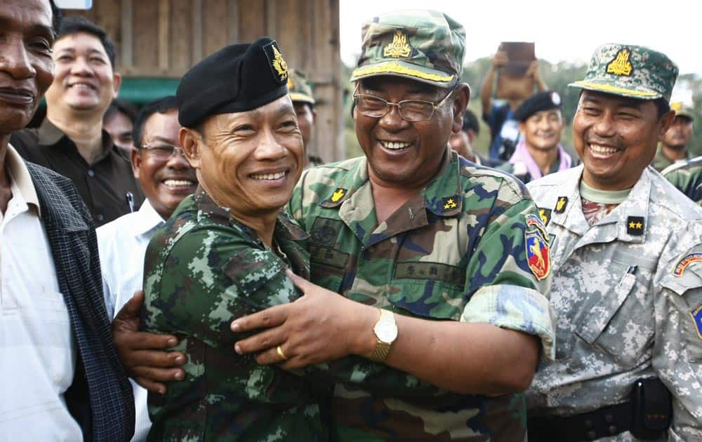 A Cambodian army commander in charge of the famed Preah Vihear Temple, Srey Doek, center right, and Thai army commander Tarakorn Thammavinthon, center left, hug each other after a meeting at the disputed Cambodia-Thai border in Preah Vihear Province, Cambodia.