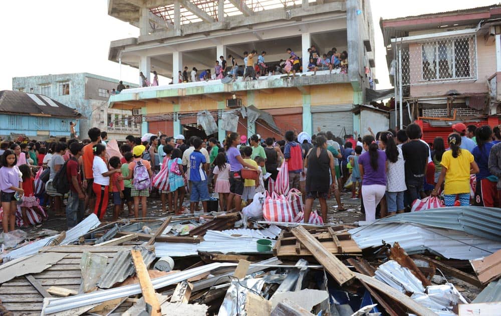 Residents watch as others throw goods from a warehouse in Guiuan, Eastern Samar province, central Philippines.