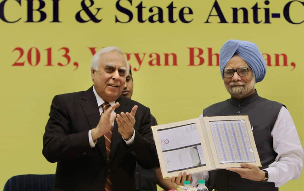 Prime Minister Manmohan Singh releasing a special commemorative stamp as Union Minister for Communications and IT Kapil Sibal looks on during the Central Bureau of Investigation (CBI) conference.