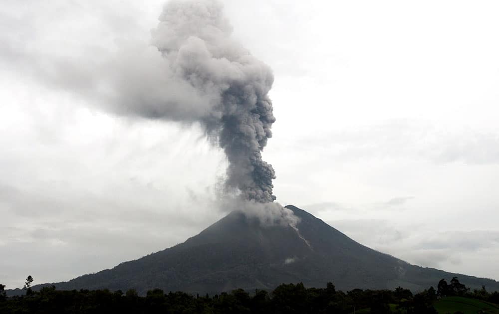 Mount Sinabung spews volcanic materials as it erupts as seen from Beras Tiga Pancur, North Sumatra, Indonesia.