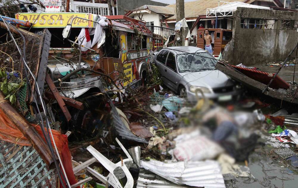 Vehicles and a body lie amongst the devastation caused by typhoon Haiyan, in Tacloban city, Leyte province central Philippines.