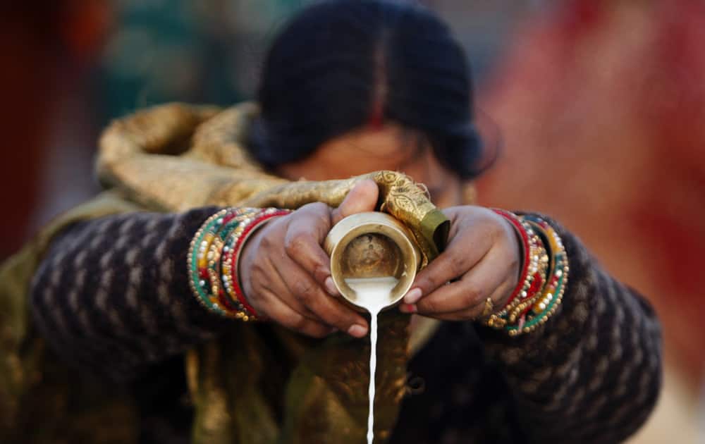 An Indian Hindu woman devotee performs rituals at River Tawi during Chhath Puja festival in Jammu.