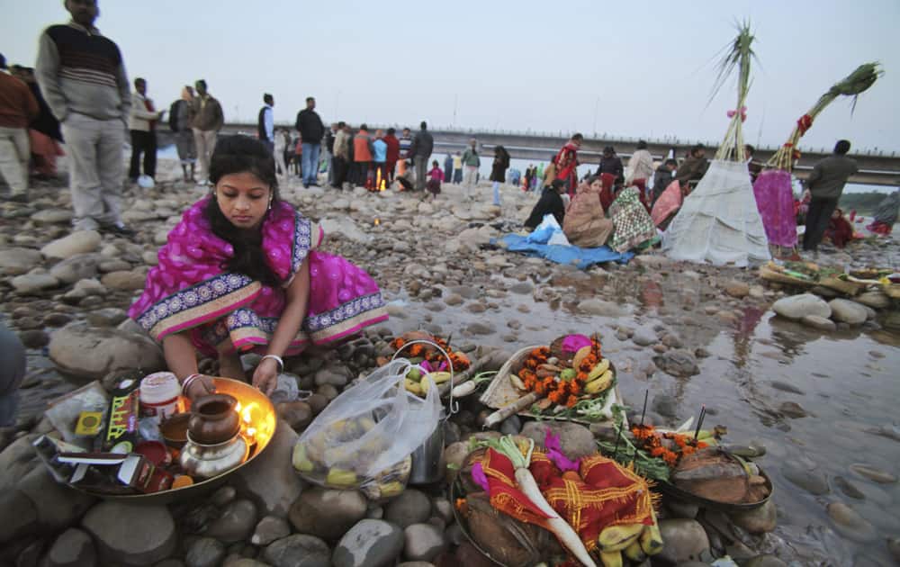A Hindu devotee performs rituals in the morning at the Tawi River during Chhath Puja festival in Jammu.
