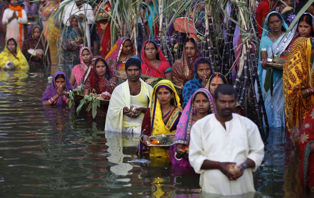 Hindu devotees stand in water as they perform rituals to the setting sun during Chhath Puja festival in Bangalore.