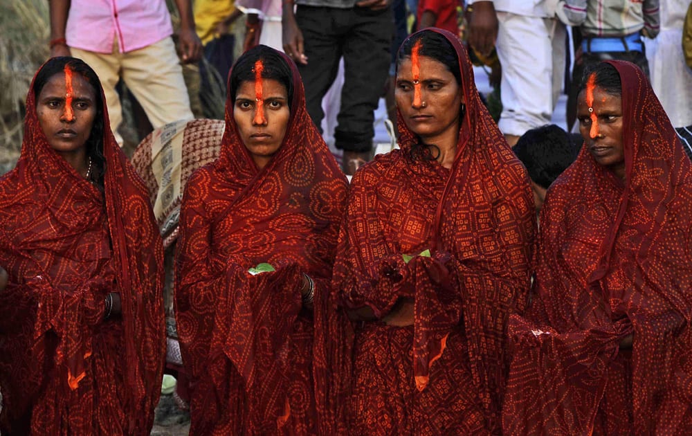 Hindu devotees perform rituals to the setting sun in the River Niranjana during Chhath Puja festival in Bodhgaya.
