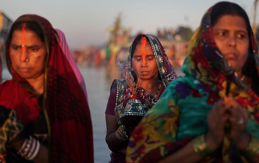 Hindu devotees perform rituals to the setting sun in the River Brahmaputra during Chhath Puja festival in Gauhati.