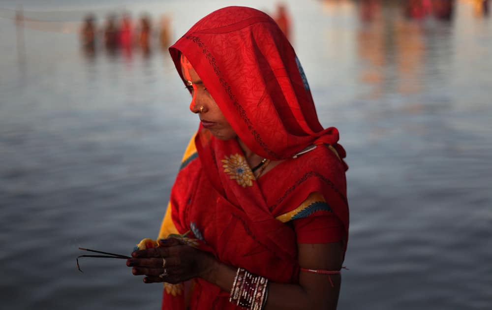 A Hindu devotee performs rituals to the setting sun in the River Brahmaputra during Chhath Puja festival in Gauhati.