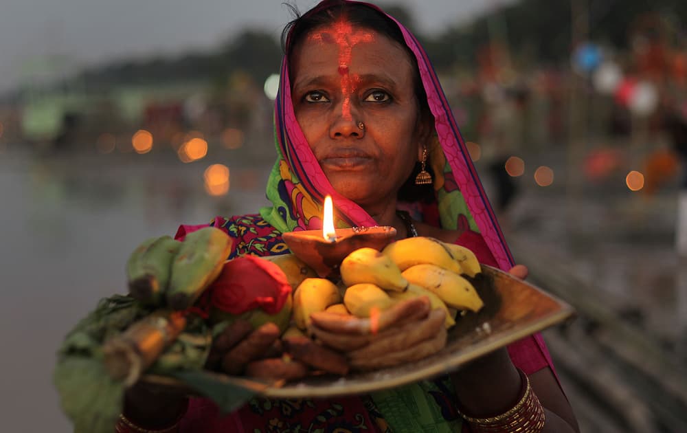 A Hindu devotee performs rituals to the setting sun in the River Brahmaputra during Chhath Puja festival in Gauhati.