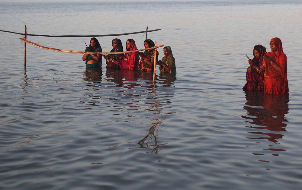 Devotees perform rituals to the setting sun in the River Brahmaputra during Chhath Puja festival in Gauhati.
