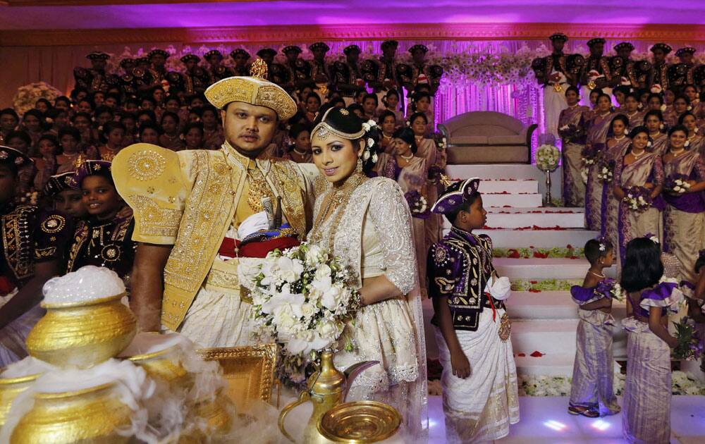 Sri Lankan couple Nalin, left, and Nisansala pose for photographers as they attempt to set a Guinness record for a wedding with the most number of bridesmaids for a bride in their wedding ceremony in Negombo, on the outskirts of Colombo.