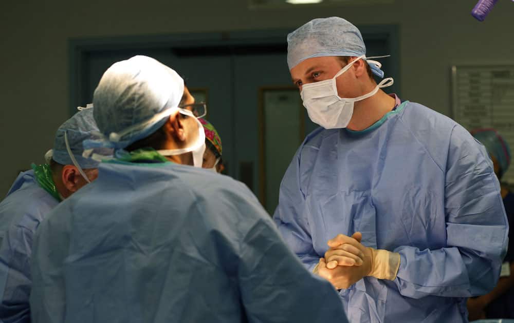 Britain`s Prince William, The Duke of Cambridge, President of the Royal Marsden NHS Foundation Trust, listens to head surgeon Pardeep Kumar, left, as he observes surgery for the removal of a bladder tumour on a male patient during a visit at the Royal Marsden hospital in London`s Chelsea.