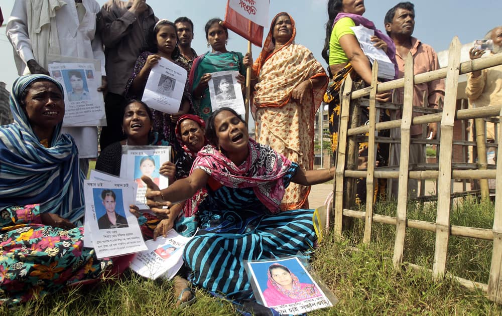 Bangladeshi relatives of the victims of the April 24 Rana Plaza building collapse wail at the Jurain graveyard after government laboratory tests identified 157 persons out of the 322 unidentified victims in Dhaka.