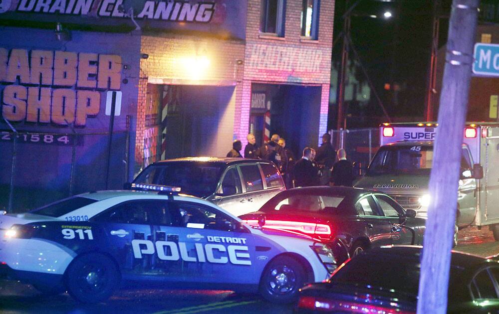 Police gather at a scene of a multiple shooting at Al`s Place Barber Shop in Detroit. Detroit police say gunfire broke out at the barbershop known for gambling activity, leaving at least two people dead.