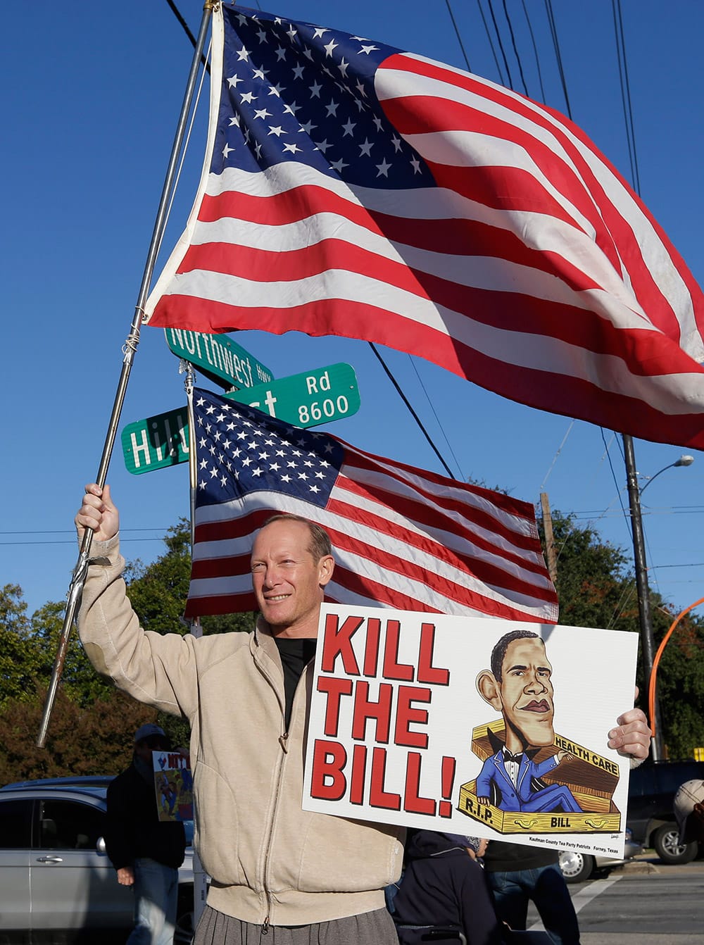 Brian Rube of Milwaukee, Wis., holds a signs and waits with other protestors for President Barack Obama to arrive at the Temple Emanu-El in Dallas.