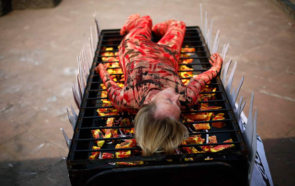 Animal rights activist and co-founder of People for the Ethical Treatment of Animals (PETA) Ingrid Newkirk lies on a mock barbecue stand as a sign of protest in Mumbai.