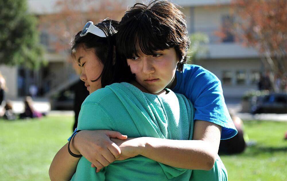 Calabasas High School students Aya McGlothlin, right, and Meili Spano embrace following a rally to support teacher Brian Ludmer at the school.