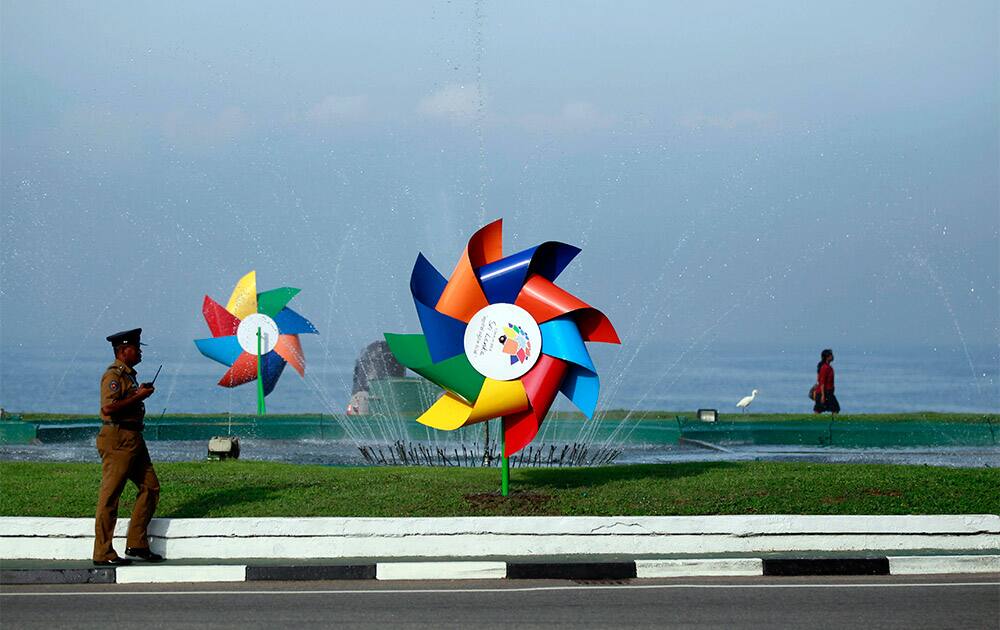 A Sri Lankan police officer walks past decorations erected for the Commonwealth Heads of Government Meeting (CHOGM) in an intersection in Colombo, Sri Lanka.