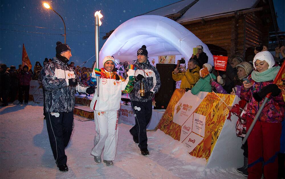 In this Monday, Nov. 4, 2013 photo provided by Olympictorch2014.com, torchbearer Marina Kaneva holds her torch near Salekhard, some 1,900 kilomters (1,180 miles) northeast of Moscow, Russia.