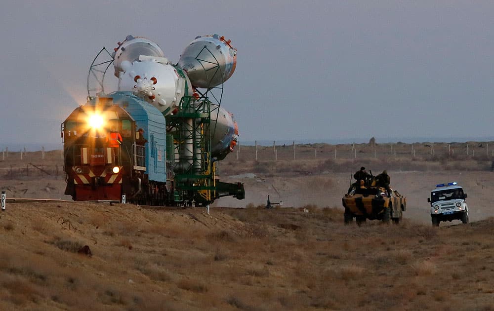 Russian police guard the Russia`s booster rocket Soyuz-FG with the space capsule Soyuz TMA-11M that will carry new crew to the International Space Station (ISS) as the rocket is transported from hangar to the launch pad at the Russian leased Baikonur cosmodrome, Kazakhstan.