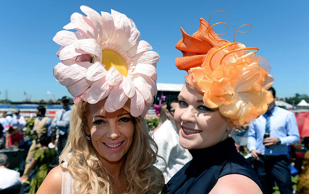 Gail Langton, left, and Aimee Skaines from Queensland pose on the lawn of the Flemington Racecourse before the Melbourne Cup horse race.