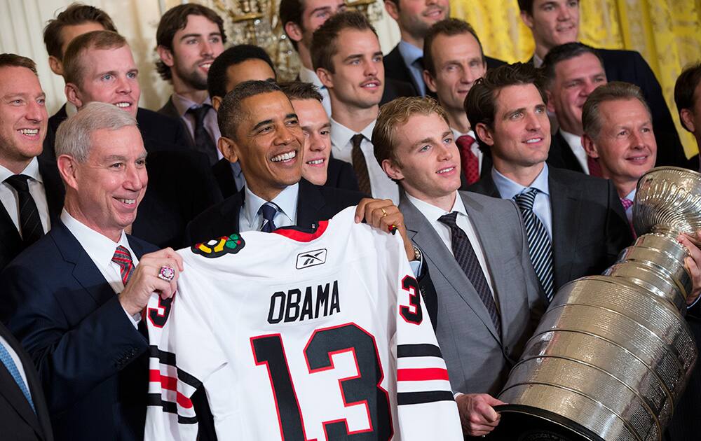 President Barack Obama holds up a Chicago Blackhawks hockey jersey during a ceremony in the East Room of the White House in Washington.