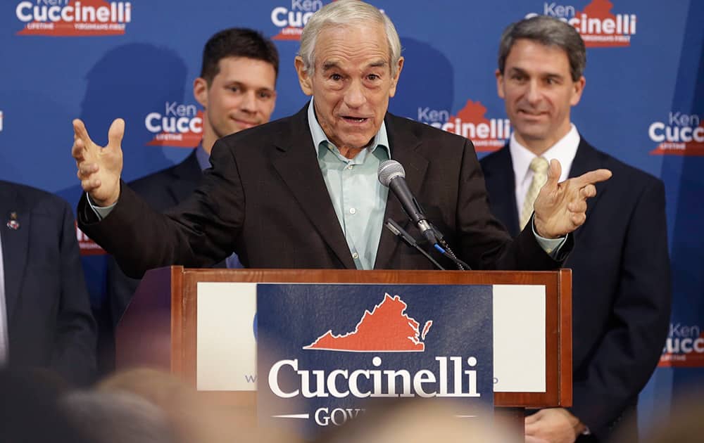 Republican gubernatorial candidate, Virginia Attorney General Ken Cuccinelli, right, listens to former U.S. Rep. Ron Paul, center, during a rally in Richmond, Va.