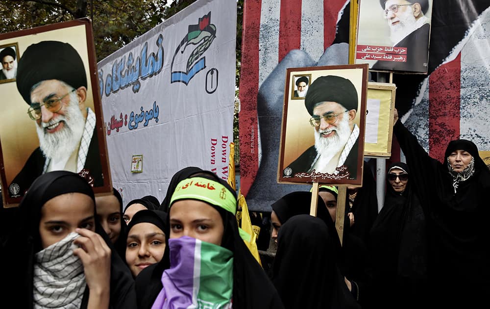 Iranian protesters hold posters with photos of supreme leader Ayatollah Ali Khamenei during an annual anti-American demonstration in Tehran, Iran.