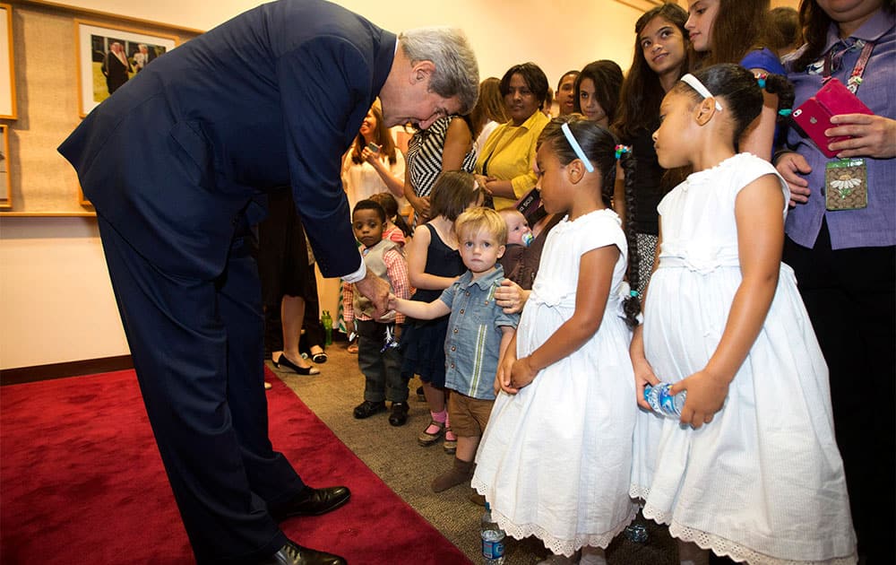 US Secretary of State John Kerry greets the children of US Embassy employees during a visit to the facility in Riyadh.