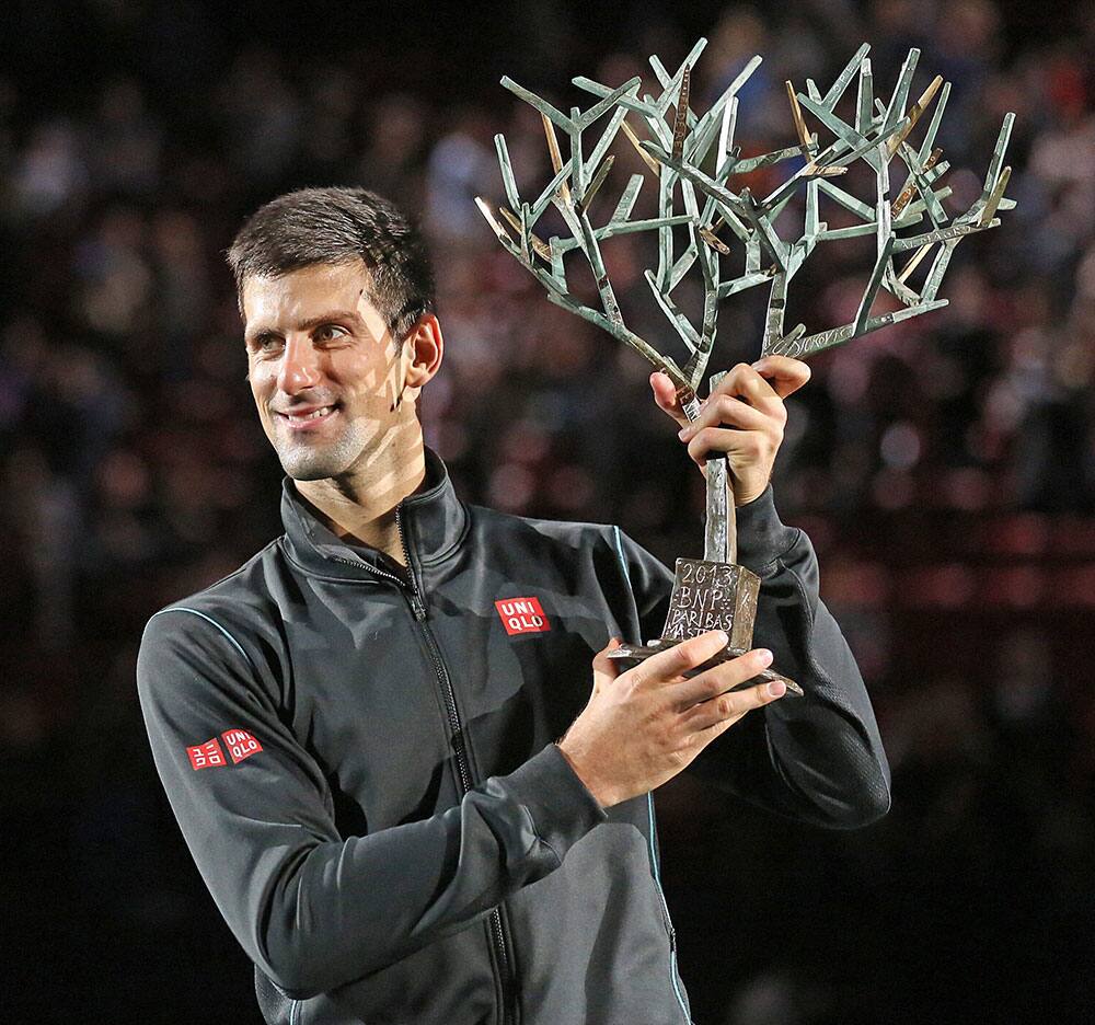 Serbia`s Novak Djokovic holds the trophy after winning the final of the Paris Masters tennis against Spain`s David Ferrer, in the Paris Bercy stadium.