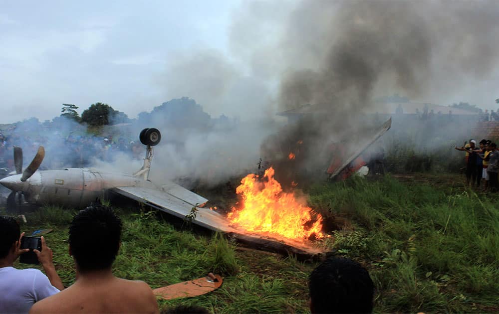 A wing of a plane of the Bolivian airline Aerocom burns after it crashed near the airport in Riveralta, Beni province, Bolivia. Bolivian authorities said the small airliner crashed while trying to land and eight people died.