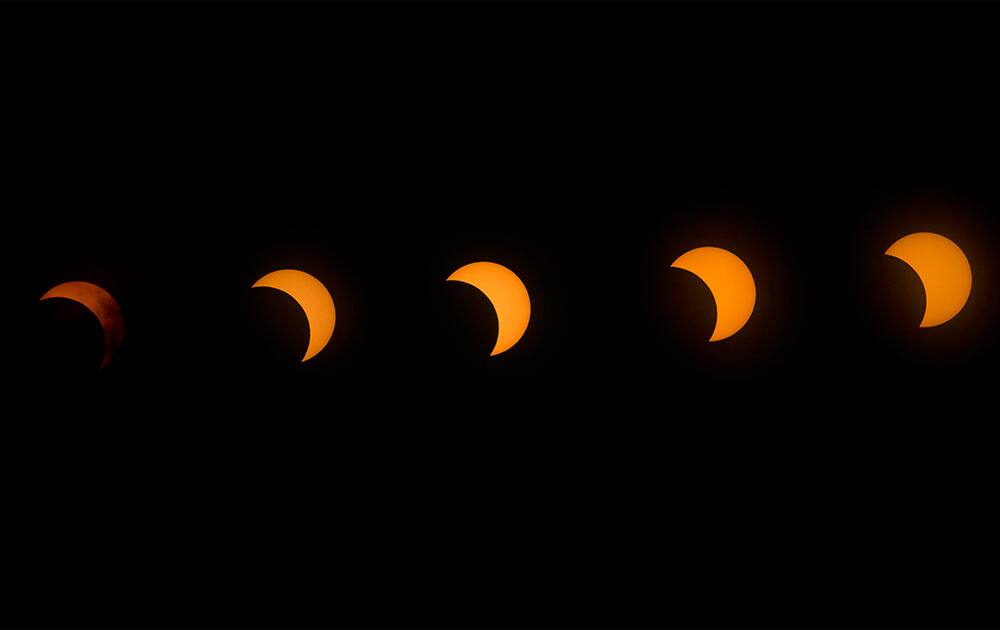 This multiple exposure image shows the transition from right to left of a hybrid solar eclipse seen over Lake Oloidien near Naivasha in Kenya.