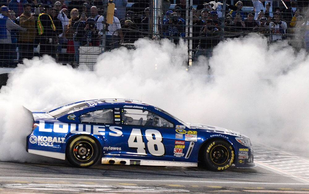 Jimmie Johnson (48) burns his tires after winning the NASCAR Sprint Cup series auto race at Texas Motor Speedway in Fort Worth, Texas.