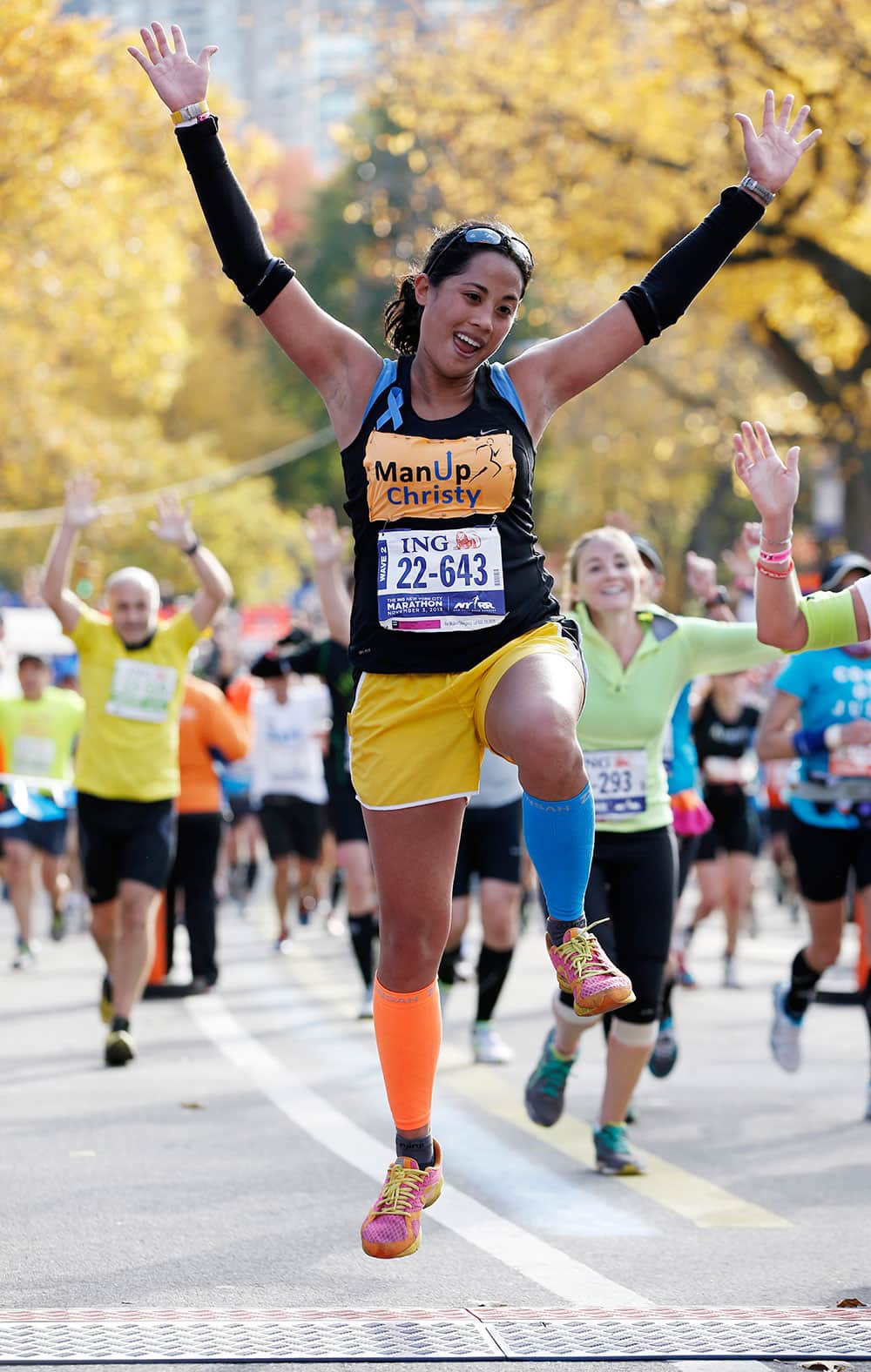 Christy Pasion of New York leaps across the finish line after completing the New York City marathon, in New York.