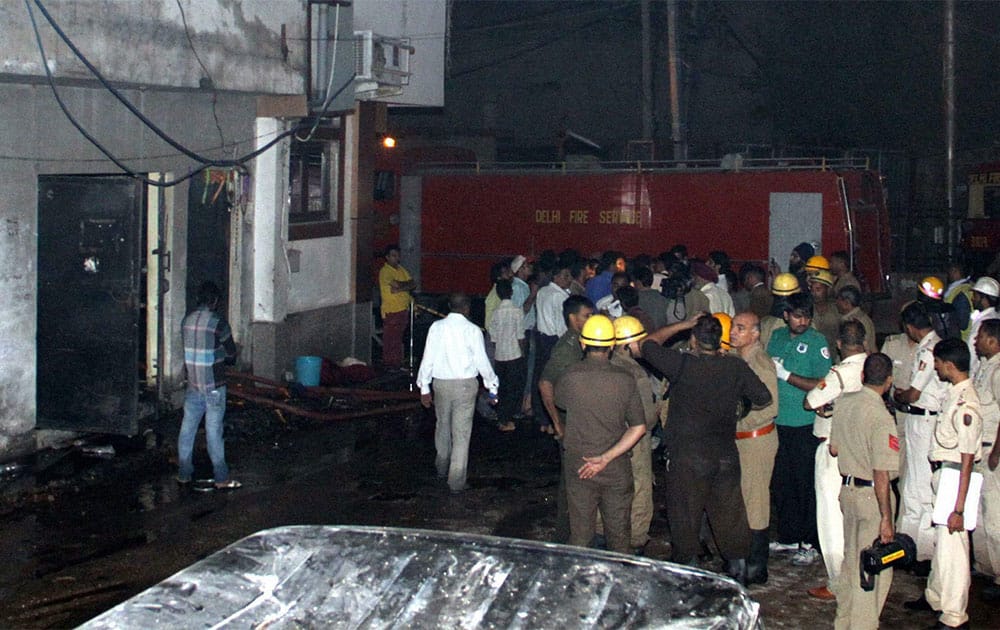 Firemen and police standing out side after fire broke out in a garment factory in Shadipur, New Delhi on Saturday night. Six people died and 10 were injured in this accident.