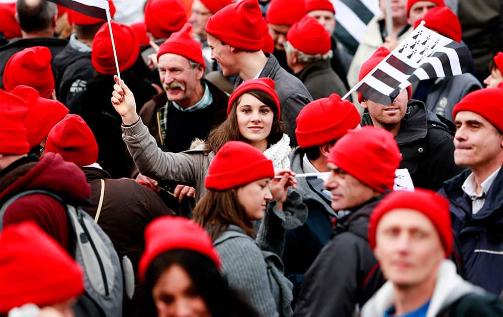 Protesters, clad in red caps reminiscent of 17th century protests, take the streets to demonstrate against job losses and a controversial environment tax in Quimper, western France.