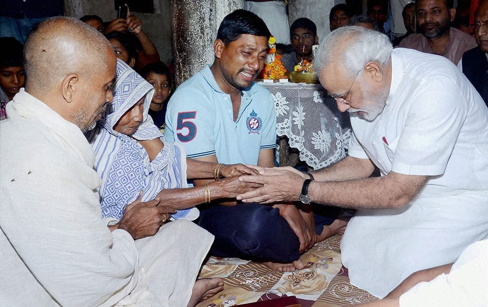 BJP`s Prime Ministerial candidate Narendra Modi consoles the family members of Rajnarian Singh, a victim of the recent serial bomb blasts, in Patna.