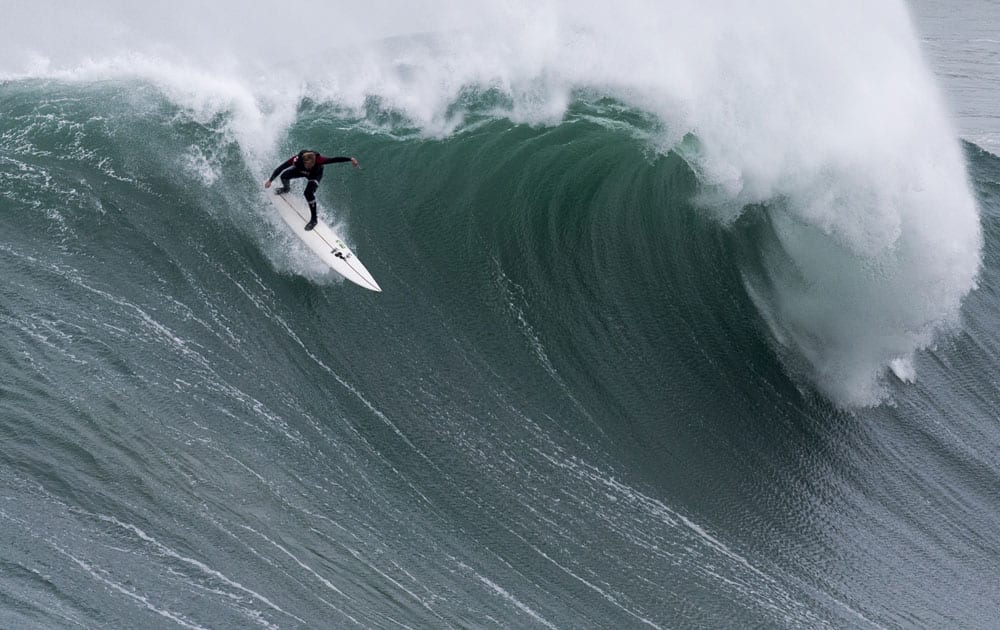 Andrew Cotton, from England, drops down a wave in Praia do Norte, north beach, at the fishing village of Nazare in Portugal`s Atlantic coast.