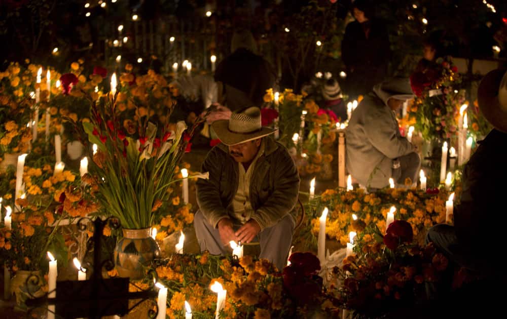 A man keeps vigil at the graveside of a relative during Day of the Dead celebrations in Atzompa, Oaxaca, Mexico.