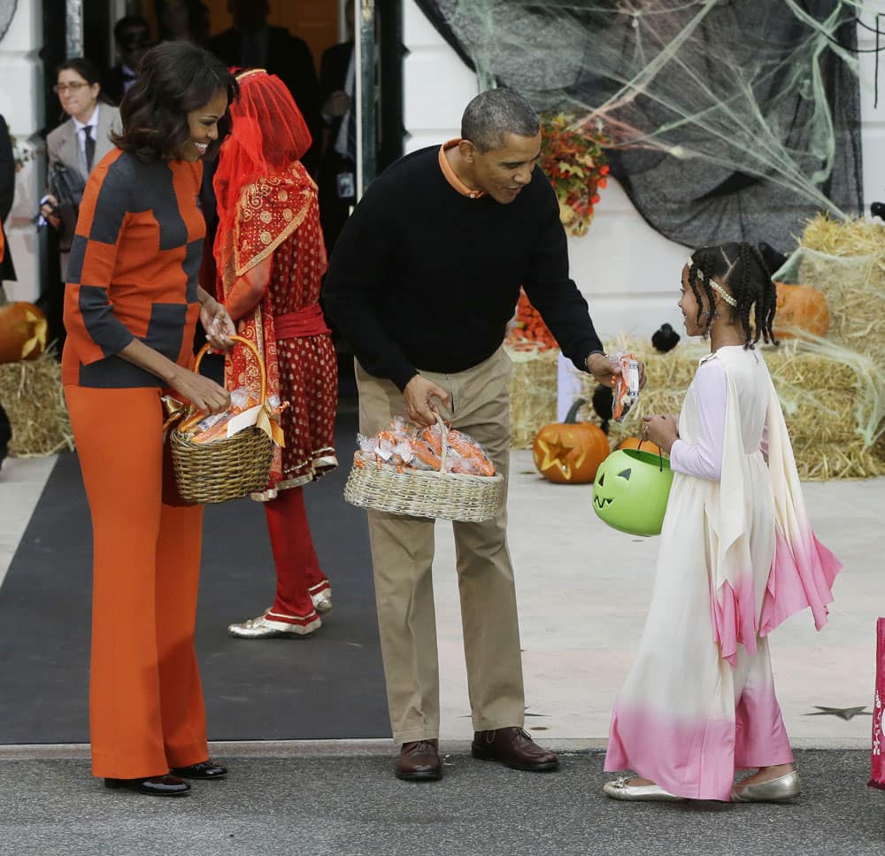 President Barack Obama, first lady Michelle Obama, hand out Halloween treats as they welcome local children and children of military families to `trick-or-treat` on the South Lawn of the White House in Washington.