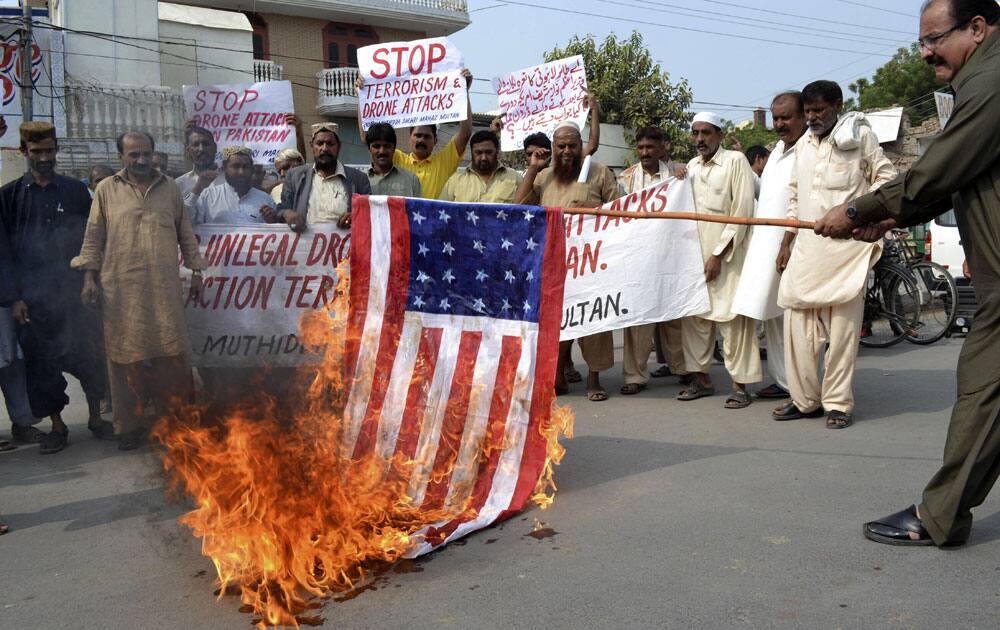 Pakistani protesters burn a representation of a US flag, during a protest to condemn US drone attacks in Pakistan, in Multan, Pakistan.