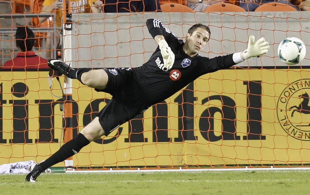 Montreal Impact goalkeeper Troy Perkins makes a diving attempt on a shot that went wide in the first half against the Houston Dynamo during a knockout-round match in the MLS Cup soccer playoffs, in Houston.