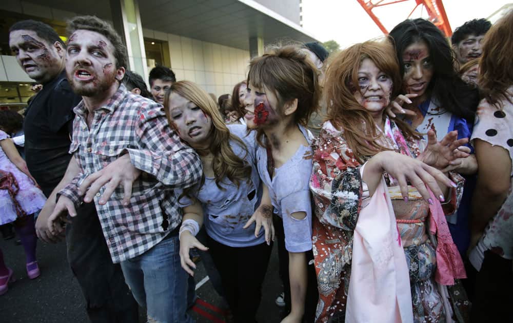 Former sumo grand champion Akebono, far left, and other participants wearing zombie makeups, perform during a Halloween event at Tokyo Tower in Tokyo.