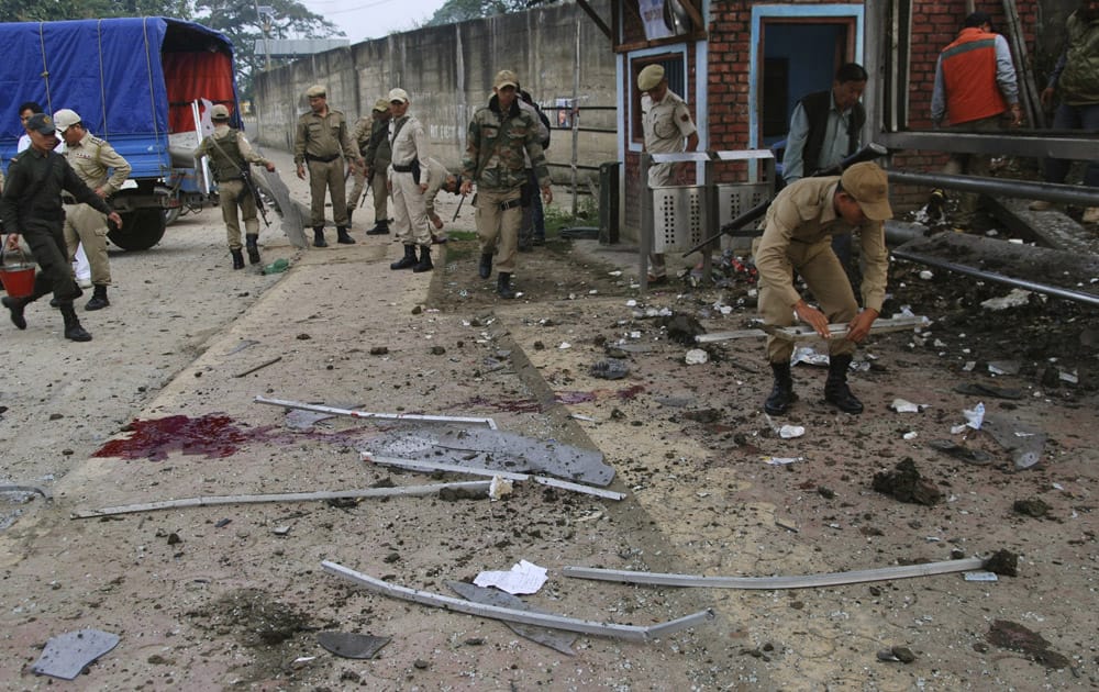 Security officers inspect the site after a crude bomb went off at a covered bus stop in Imphal, Manipur.