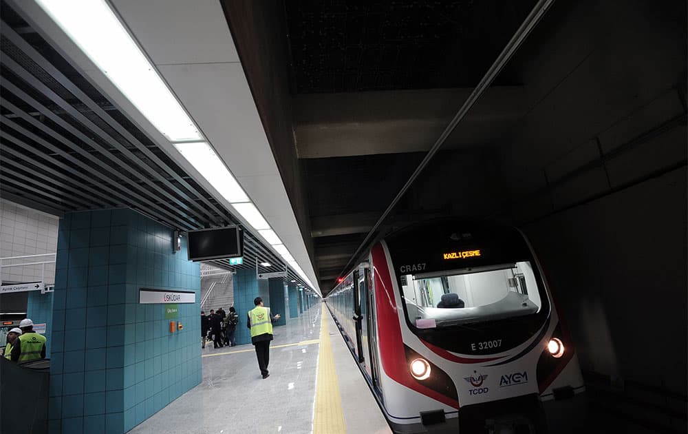Turkish officials wait outside a passenger train before the inauguration of tunnel called the Marmaray in Istanbul, Turkey. Turkey is for the first time connecting its European and Asian sides with a railway tunnel set to open Tuesday, completing a plan initially proposed by an Ottoman sultan about 150 years ago.