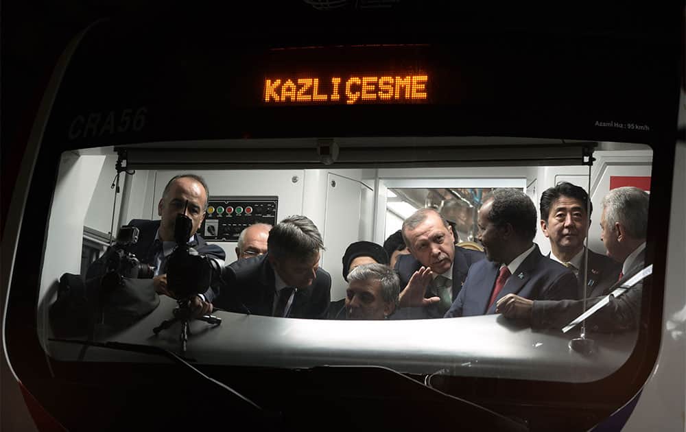 Japanese Prime Minister Shinzo Abe, second right, his Turkish counterpart Recep Tayyip Erdogan, fourth right, and other officials wait inside a train to cross the Bosporus after the inauguration of the tunnel called the Marmaray in Istanbul, Turkey.
