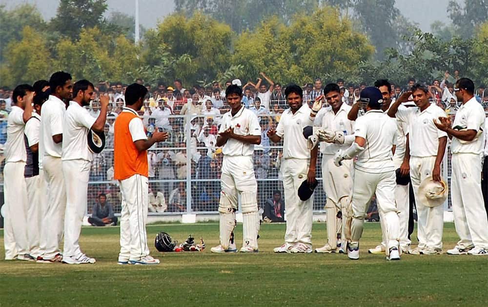 Haryana team members welcome to Mumbai`s Sachin Tendulkar as he coming to bat during their Ranji trophy in Rohtak on Tuesday. Sachin is playing his last Ranji match.