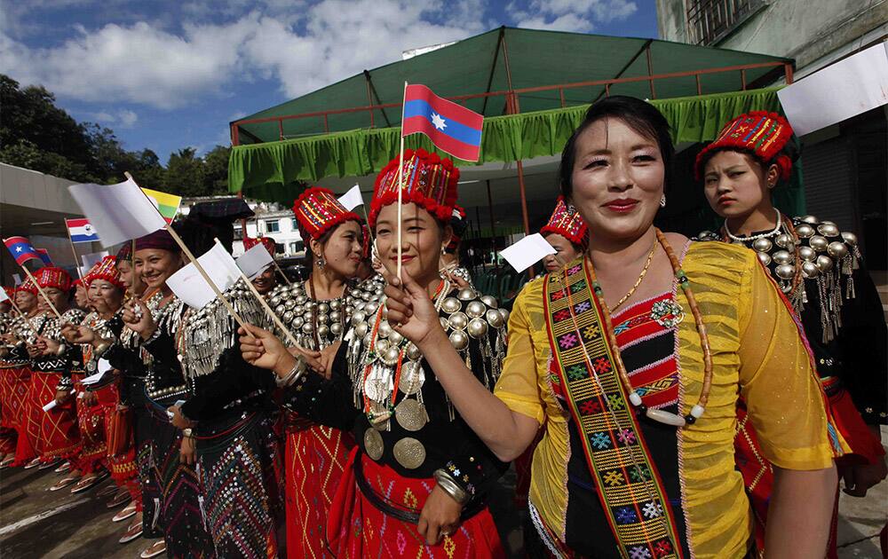 Clad in Kachin traditional costumes, women dance with miniature flags of ethnic rebels as they welcome other ethnic rebels during a nationwide ceasefire conference at the headquarters of KIA in Laiza, a border town of China and Myanmar, Kachin State, Myanmar.