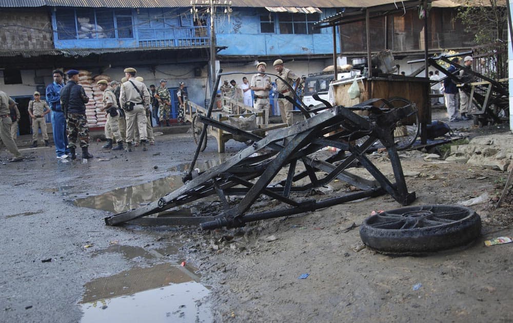 Security men stand at the site where a crude bomb exploded near the Khwairamband market in Imphal.