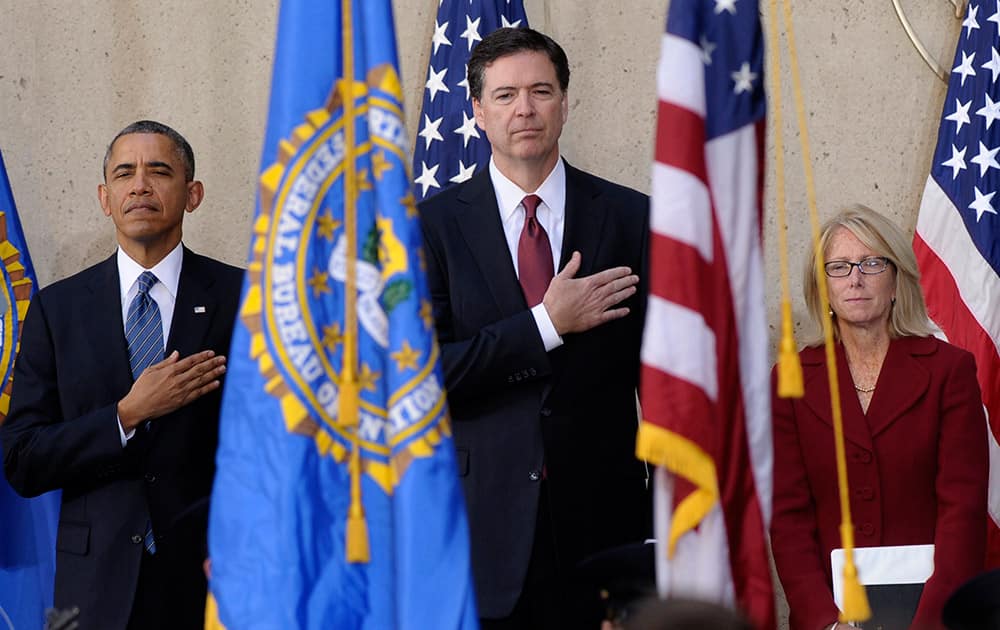 President Barack Obama stands with James Comey, center, and his wife Patrice Failor, right, during the singing of the National Anthem at Comey`s installation as FBI Director, at FBI Headquarters in Washington.