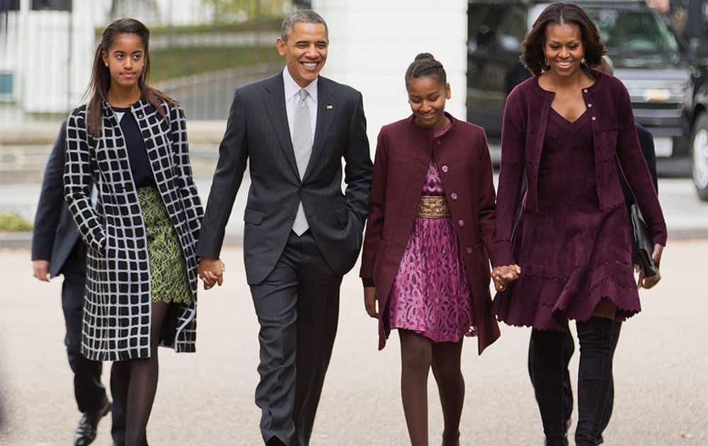 President Barack Obama with first lady Michelle Obama, and their daughters Malia and Sasha, walk from the White House in Washington to attend a church service.